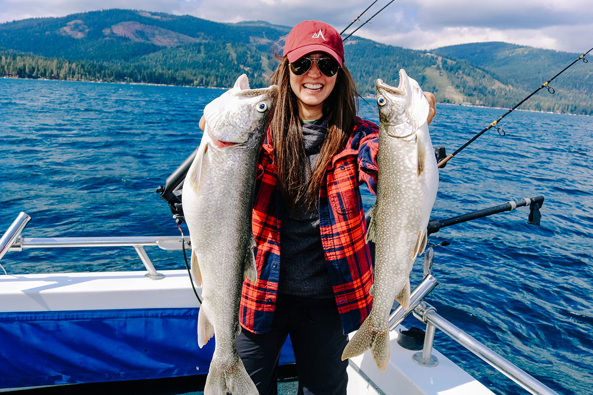 a person holding a fish on a boat in a body of water